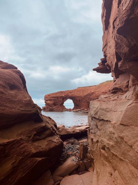istock Red sandstone cliffs under an overcast sky at Cavendish Beach, Prince Edward Island, Canada 1432821864