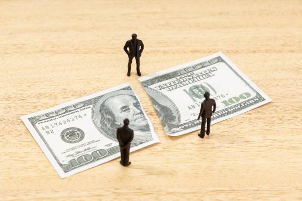 istock Fake torn dollar banknote and human figurines on wooden table 1432822182