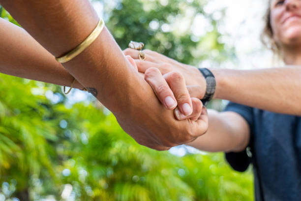Shot of two females holding hands, diversity in skin color Unrecognisable women hand in hand holding each other for trust faith and hope. Two different skin tones, multiracial group anonymous activist network stock pictures, royalty-free photos & images
