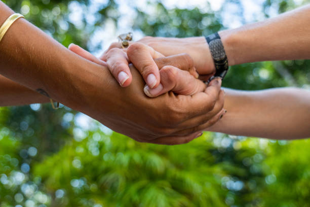 Shot of two females holding hands, diversity in skin color Unrecognisable women hand in hand holding each other for trust faith and hope. Two different skin tones, multiracial group anonymous activist network stock pictures, royalty-free photos & images