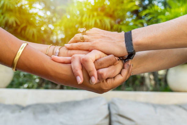 Shot of two females holding hands, diversity in skin color Unrecognisable women hand in hand holding each other for trust faith and hope. Two different skin tones, multiracial group anonymous activist network stock pictures, royalty-free photos & images