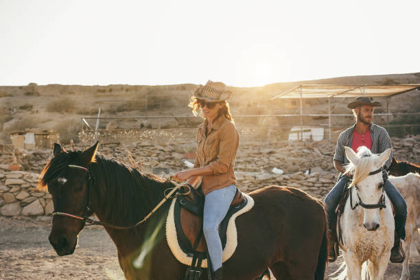 istock Young people riding horses doing excursion at sunset - Focus on woman hand 1432826719