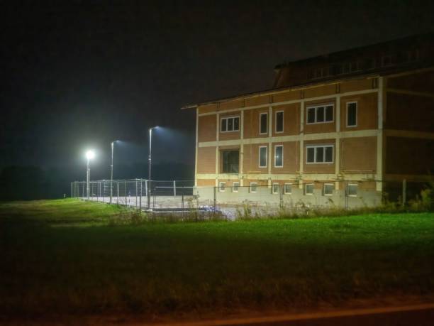 The stone building illuminated by street lamps at night.