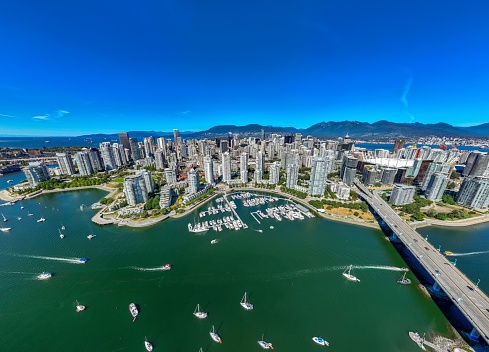 An aerial drone view of downtown of Vancouver with modern buildings under a blue sky