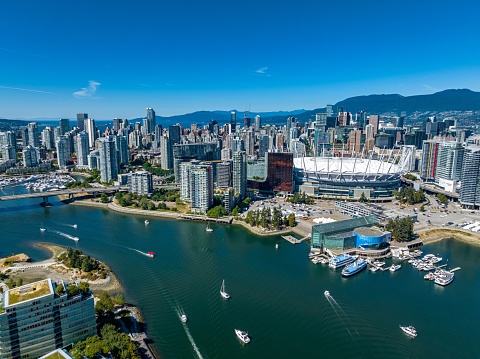 An aerial drone view of the downtown of Vancouver with modern buildings and a port with moored boats