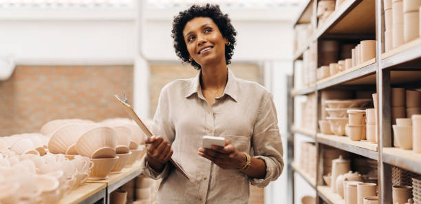 彼女の店の新しいアイデアを熟考する陽気な女性陶芸家 - potter small business pottery happiness ストックフォトと画像