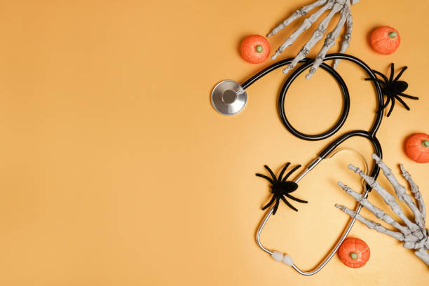 Halloween decor and stethoscope on yellow background with copy space. Medical Halloween