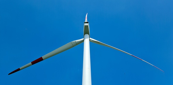 Detail of wind power plant in blue sky with symmetric blades