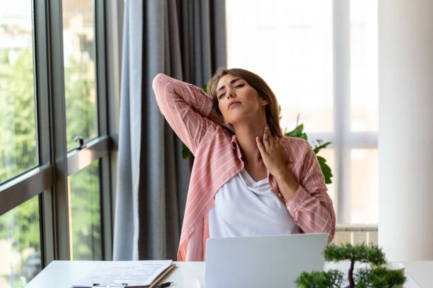istock Feeling exhausted. Frustrated woman looking exhausted and massaging her neck while sitting at her working place 1432842562