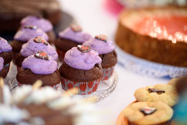istock Selective focus of chocolate cupcakes with violet topping on the festive table, blurred background 1432843347