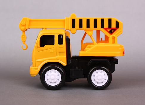 Toy truck with crane isolated on gray background