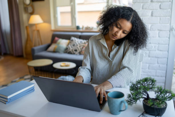 istock Young woman is studying at home using cell phone and laptop 1432844379