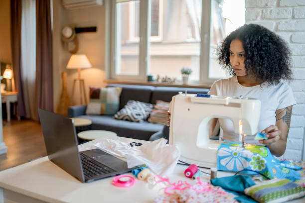 istock Young woman's learning sewing homemade clothes for online e-business 1432844387