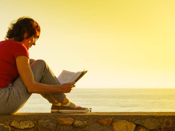 istock Woman on sea read book, relaxing 1432849101