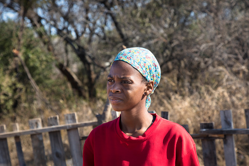 young African woman with a blue scarf in a village in Botswana