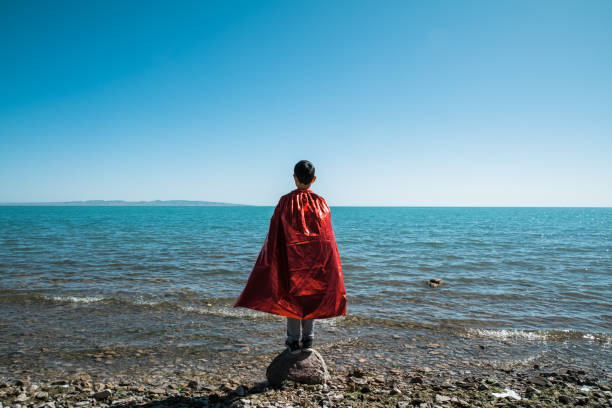 Young superman looking and contemplating towards lake