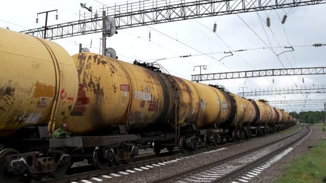 A freight train passes through the crossing with tank cars.