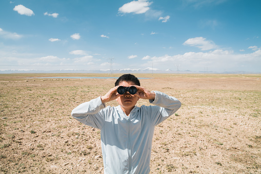 Young boy enjoying scenery with binoculars at Hoh Xil