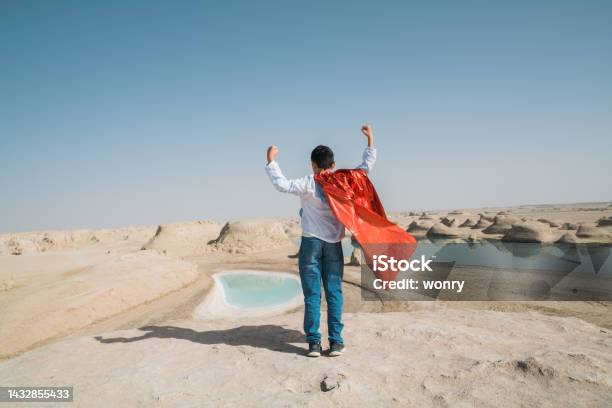 Young Superman Showing Muscles At Yardang Hill Stock Photo - Download Image Now - 10-11 Years, Adventure, Arms Raised