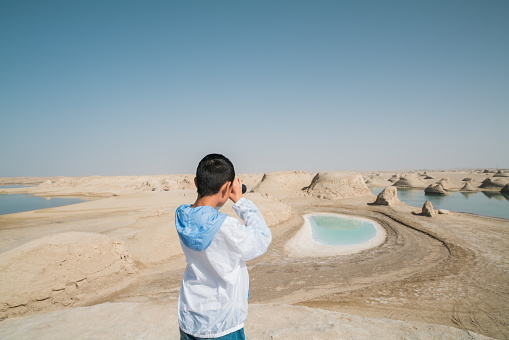 Young boy enjoying scenery with binoculars at Yardang hill