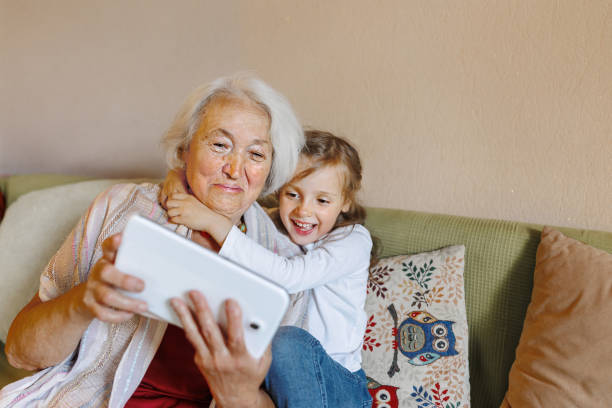 istock Grandmother and granddaughter on the sofa using a tablet together 1432859193