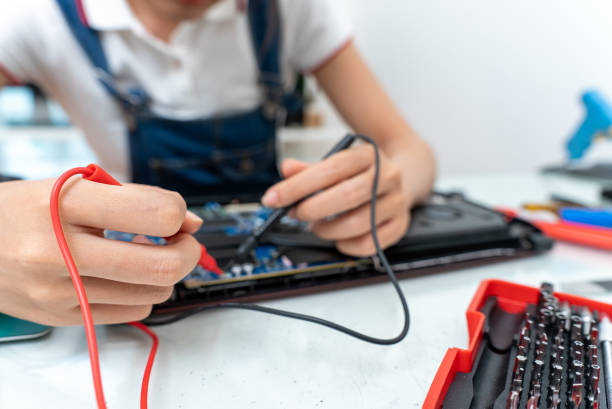 istock Asian woman using a power meter to check laptop board to repair or replace. 1432859869