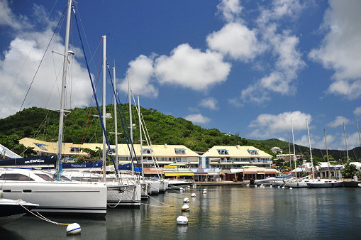 Marigot, Collectivity of Saint Martin / Collectivité de Saint-Martin, French Caribbean: Marina Port la Royale with catamarans at their moorings, a trendy area for shopping and dining - green hills in the background - sxm.