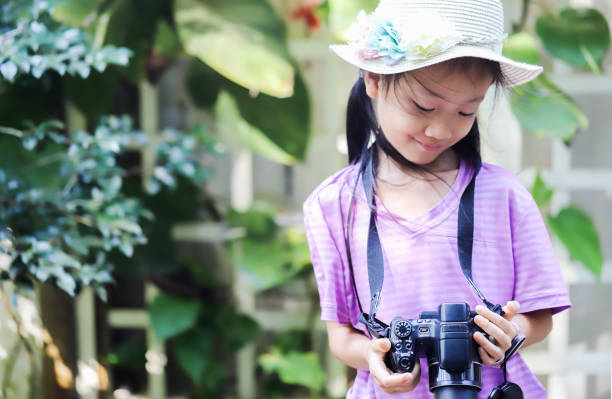 istock a Asian girl take photos with a digital camera. 1432865798