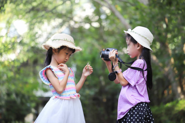 istock Asian girls playing and taking photos with a lizard. 1432865971
