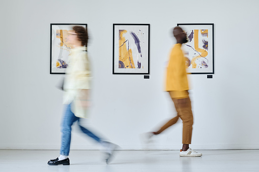 Blurred motion of young people walking along art gallery