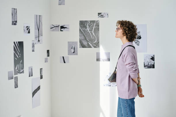 istock Woman examining pictures at gallery 1432867607