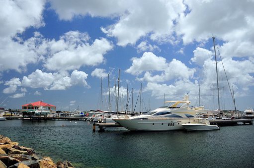Marigot, Collectivity of Saint Martin / Collectivité de Saint-Martin, French Caribbean: yachts moored by the town center with the harbormaster building on the left (capitainerie) - Fort Louis Marina, Marigot bay, Caribbean sea.