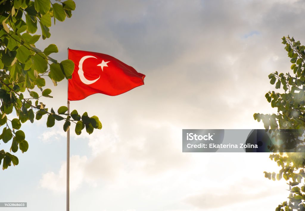 The flag of Turkey is developing in the blue sky. The flag of Turkey is developing in the blue sky Blue Stock Photo