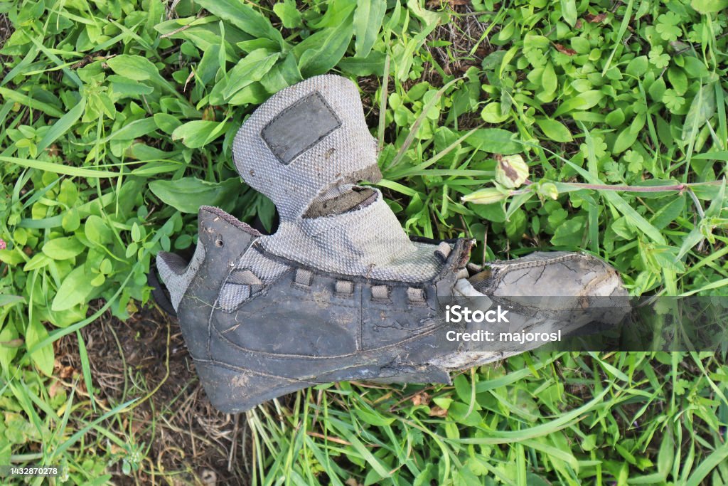 Old ruined brogue shoe in the grass Abandoned Stock Photo