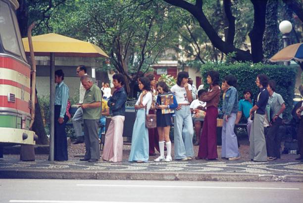 Queue at a bus stop in Rio de Janeiro Rio de Janeiro, Brazil, 1976. Queue at a bus stop in Rio de Janeiro. flare pants stock pictures, royalty-free photos & images