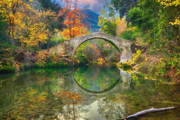 istock Ancient roman bridge surrounded by yellow trees 1432875400