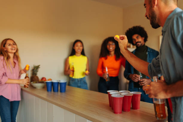 istock Friends playing beer pong at party. 1432879339
