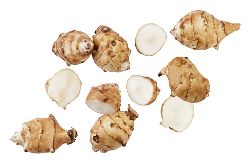 Jerusalem artichoke and pieces are flying on a white background. Isolated set