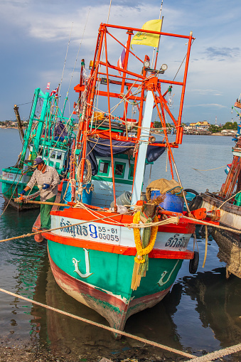 Thai Fisher Boats at a Fishing Pier in Naklua Thailand Asia\nThe picture shows the fishing boats returning in the late afternoon after a daily fishing trip.\nThese boats are lashed to a pier or mooring\nPattaya District Chonburi Thailand Southeast Asia\n10/12/2022