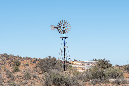 A windmill and rusted corrugated iron dam on the road between Loxton and Fraserburg in the Northern Cape Karoo