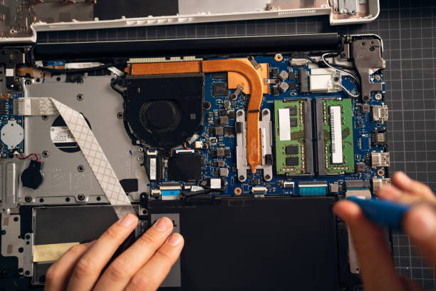 Unrecognizable man with screwdriver repairing his laptop