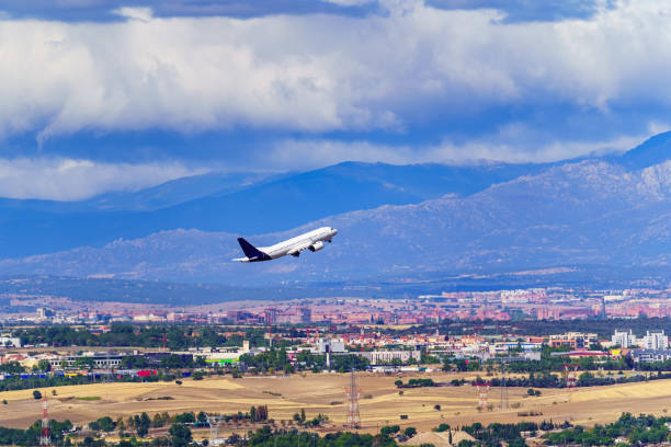 istock Generic Avio taking off and taking height next to a city and large mountains in the background. 1432883308
