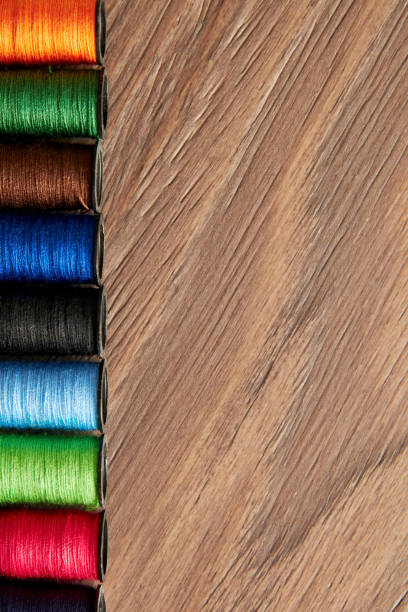 istock Vertical background with row of colorful sew thread spools on the wooden table 1432883856