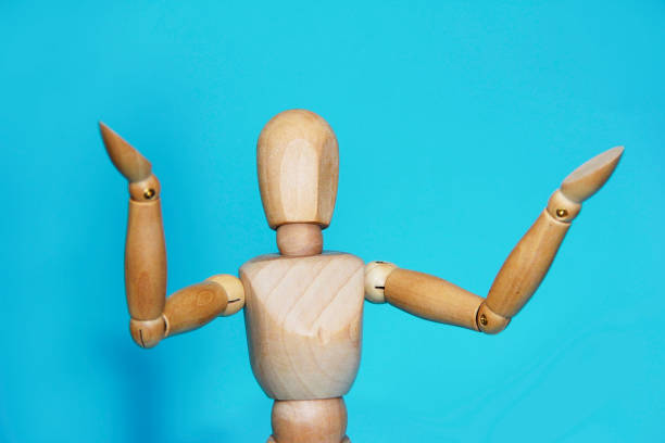 istock yellow wooden mannequin poses and gestures with his hands on a blue background 1432884162