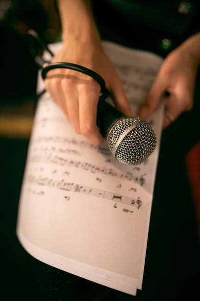 istock Unrecognizable female musician holding microphone and musical notes 1432887666
