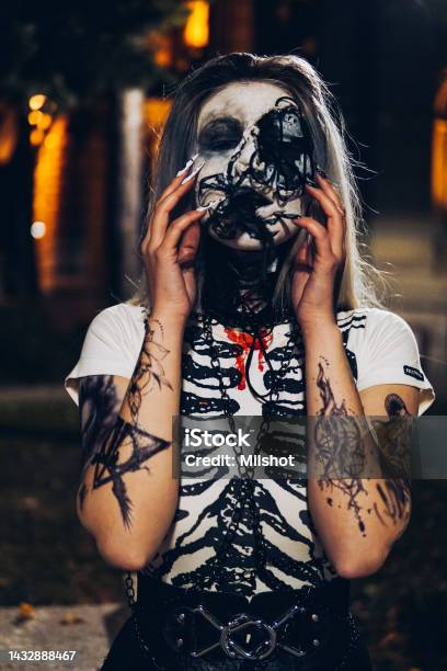 Woman With Scary Sceleton Face Painting Mask And Drawn Tattoos On Arms Stock Photo - Download Image Now