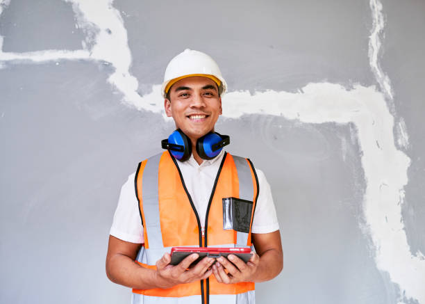 an asian construction worker smiles looking at camera with digital tablet - building contractor engineer digital tablet construction imagens e fotografias de stock