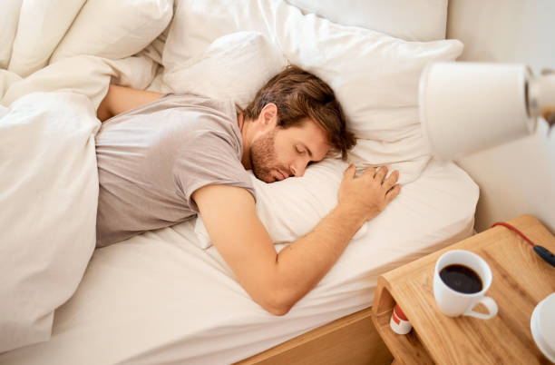 Sleeping, resting and sleepy man lying in bed with his eyes closed in a deep sleep in his bedroom. Rest, relax and tired person at home dreaming and relaxing at his house taking a late morning nap hombre dormido, descansando y somnoliento acostado en la cama con los ojos cerrados en un sueño profundo en su habitación. descansar, relajarse y persona cansada en casa soñando y relajándose en su casa tomando una siesta a última hora de la mañana