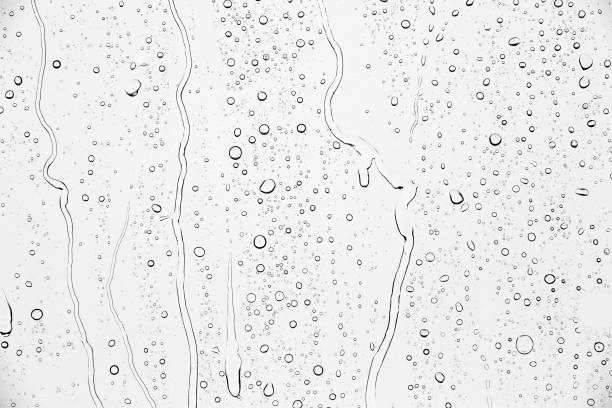 istock Drops of rain on glass against blue sky and white clouds. 1432890241