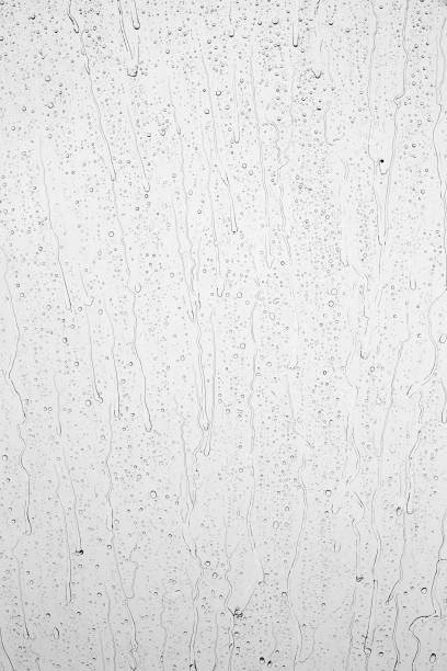 istock Drops of rain on glass against blue sky and white clouds. 1432890242